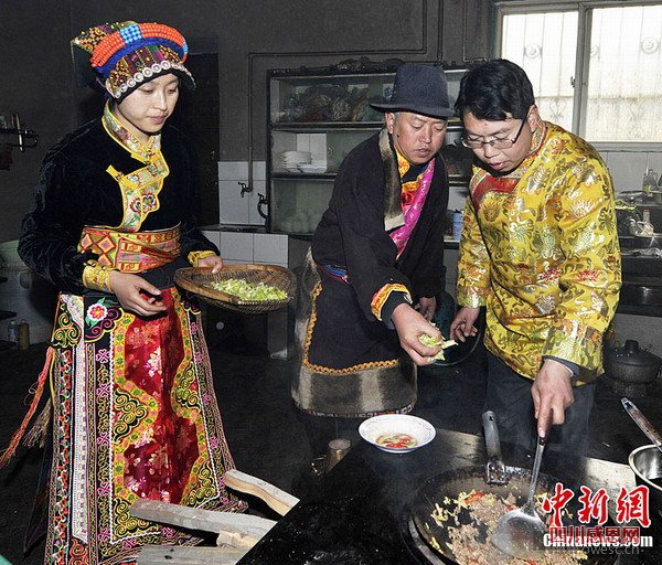 薛良义一家正在厨房烹饪食物。安源 摄